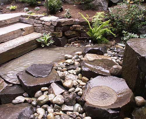 Landscape steps and rock water feature by Environmental Construction