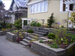Landscaper in Seattle improves curb appeal with a terraced concrete block wall and garden beds.